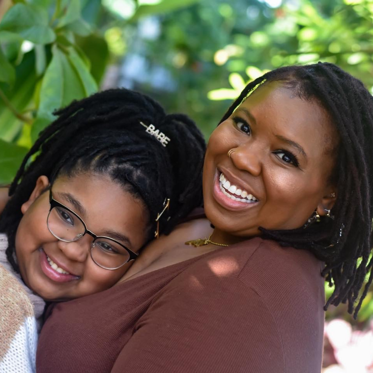 The GloË by Zoë founders smiling together outdoors.